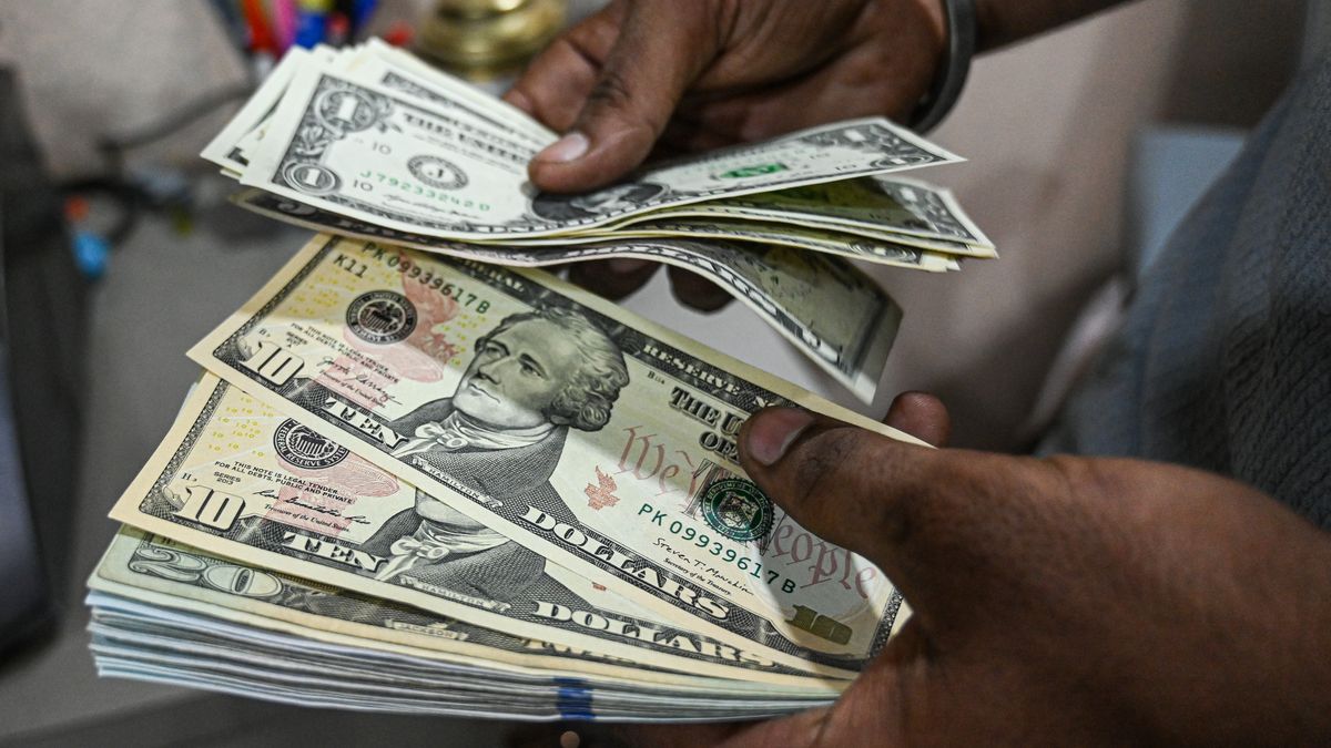 An employee counts US dollar banknotes at a currency exchange in New Delhi, India, on Saturday, Aug. 30, 2025. The Indian rupee slumped to a record low versus the dollar on concern that 50% US tariffs will hurt the country's economic growth and corporate earnings. Photographer: Prakash Singh/Bloomberg via Getty Images