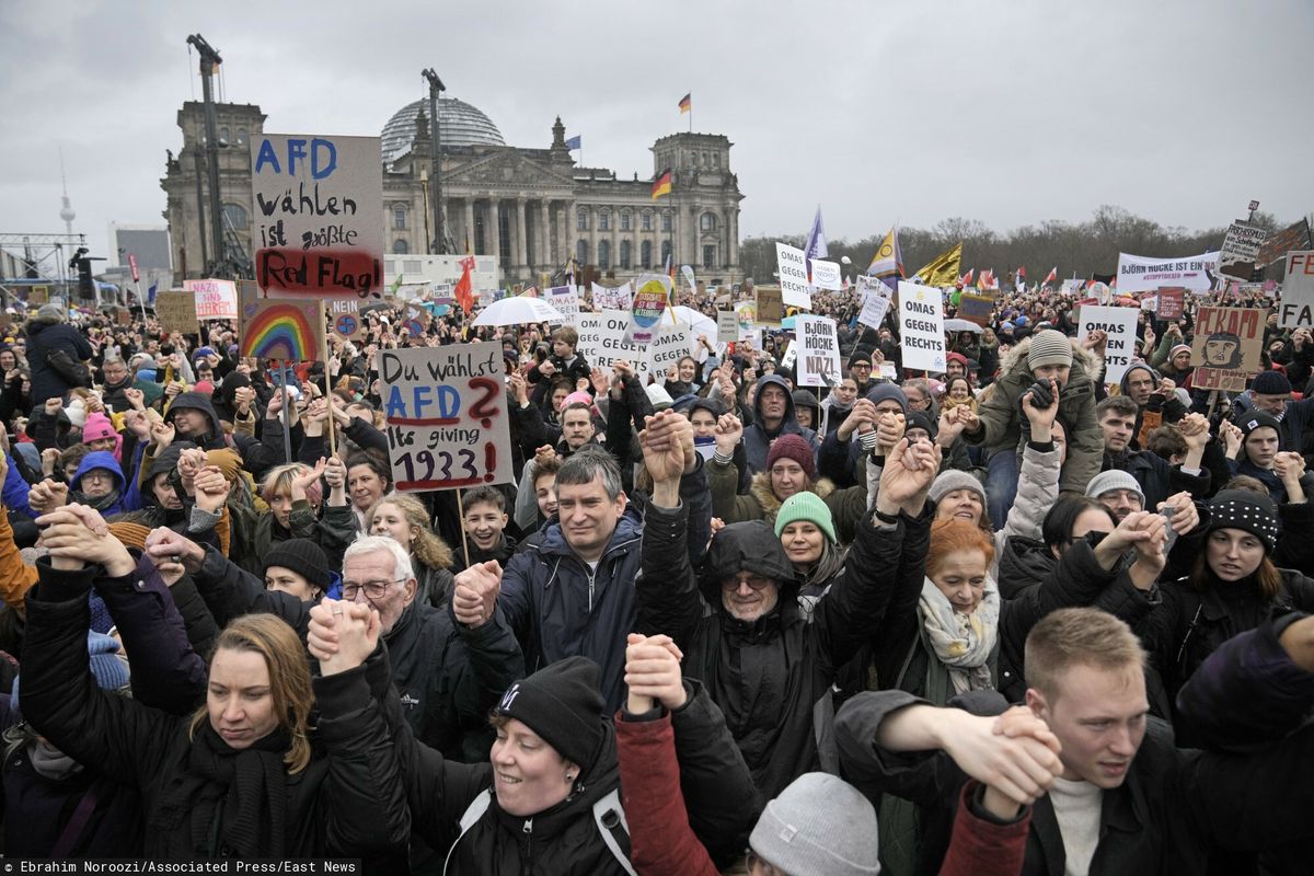 Ludzie trzymają się za ręce przed niemieckim parlamentem Reichstagiem podczas demonstracji przeciwko partii AfD i prawicowemu ekstremizmowi w Berlinie, Niemcy, sobota, 3 lutego 2024 r