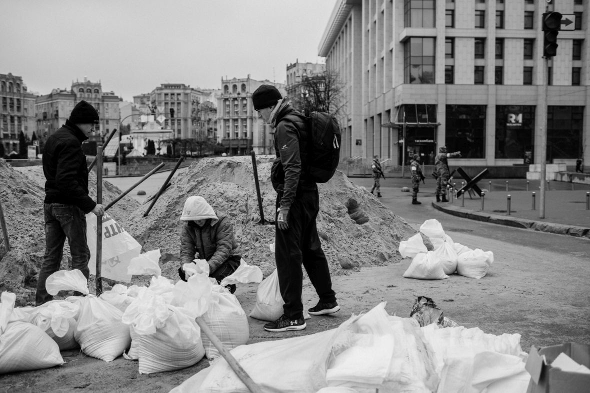 Grupa młodych mężczyzn napełnia worki piaskiem. Kijów, 3 marca 2022 roku