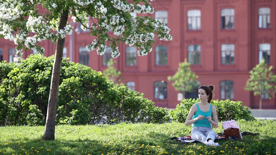 MOSCOW, RUSSIA  MAY 17, 2021: A woman sits under a blooming tree in a park. On May 17, 2021, daytime temperature is expected to reach +26-28 degrees Celsius. An orange weather warning has been issued due to the heat wave. Mikhail Tereshchenko/TASS (Photo by Mikhail Tereshchenko\TASS via Getty Images)