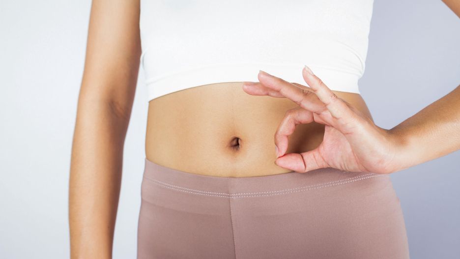 Kobiecy brzuch i symbol dłoni oznaczający "ok"