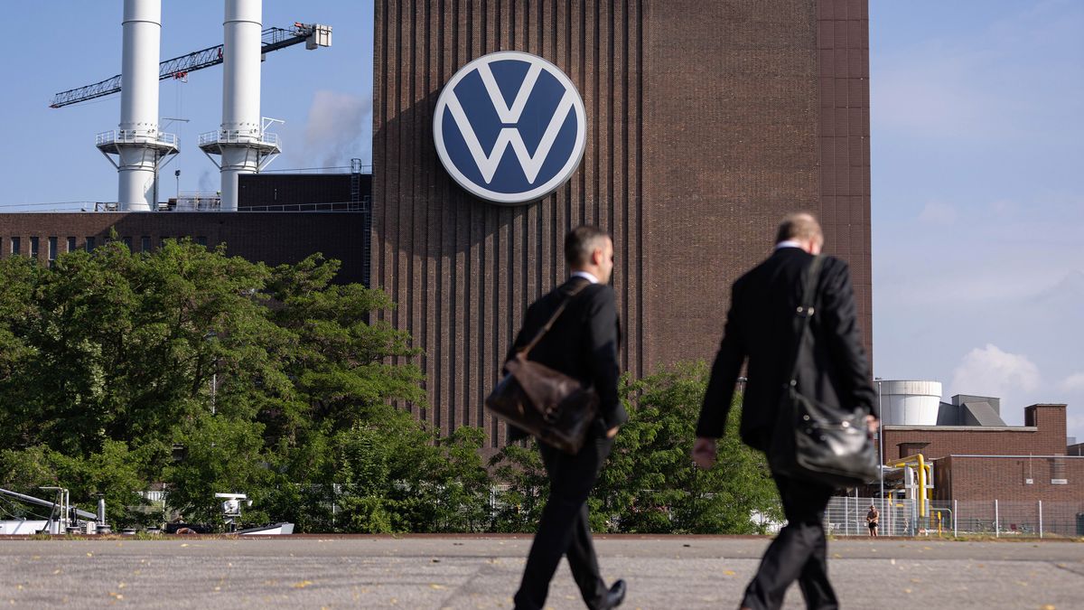 Workers pass a VW sign at the Volkswagen AG factory in Wolfsburg, Germany, on Thursday, May 23, 2024. Auto sales in Europe rose 12% in April as manufacturers including Volkswagen AG and Renault SA benefited from robust demand for plug-in and conventional cars in several major markets. Photographer: Krisztian Bocsi/Bloomberg via Getty Images