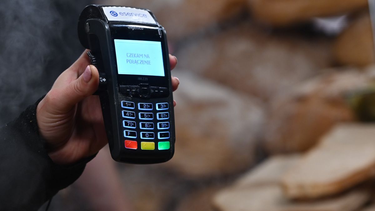 A vendor holds a card reading payment machine inside a stand with traditional Polish food at the crowded Christmas Market on the Main Market Square in Krakow.
On Friday, November 25, 2022, in Krakow, Lesser Poland Voivodeship, Poland. (Photo by Artur Widak/NurPhoto via Getty Images)