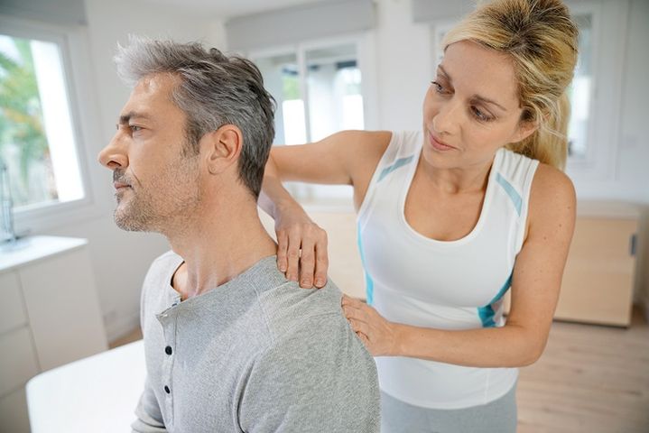 kobieta fizjoterapeuta wykonuje masaż pacjentowi mężczyźnie