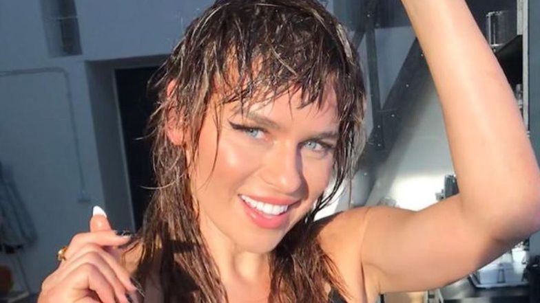 Natasza Urbańska pozuje w otoczeniu przyrody i zielonkawej wody