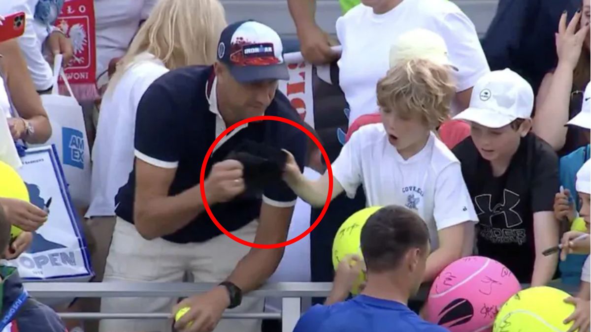 Piotr Szczerek zabierający dziecku czapkę 