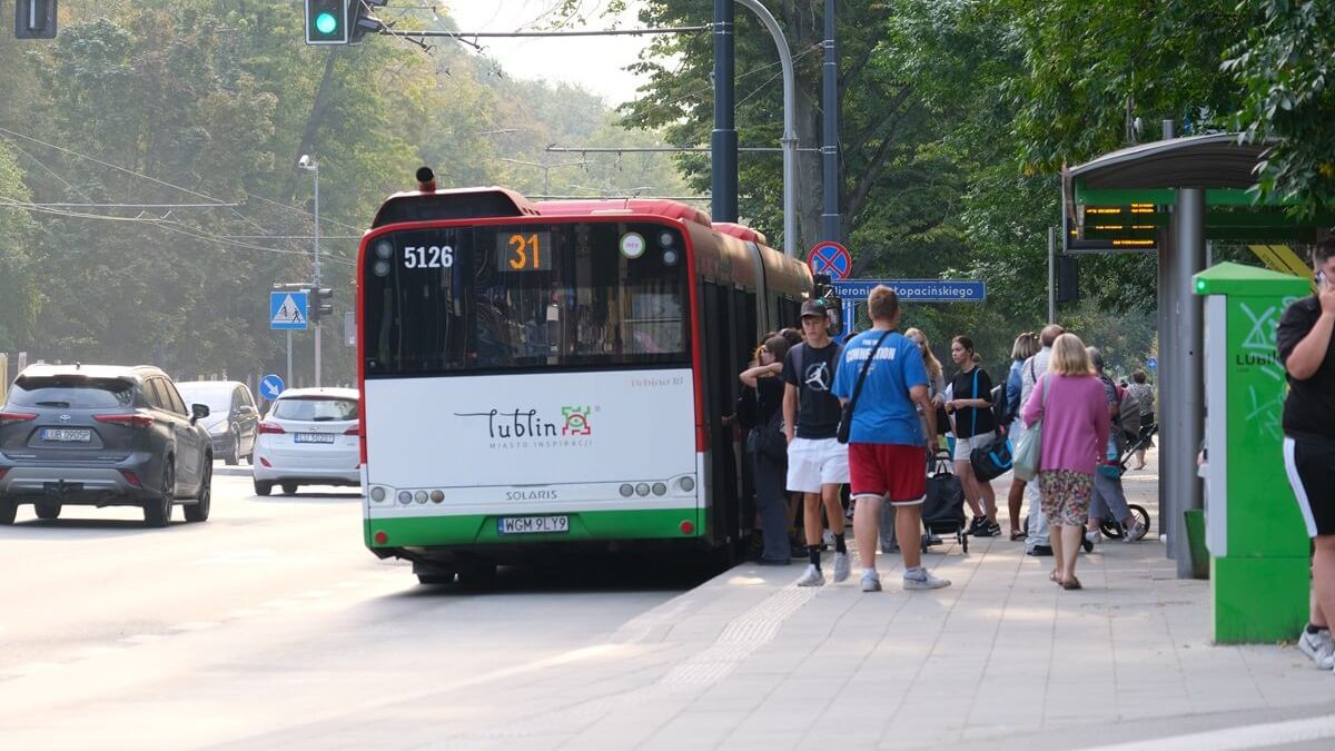 Pasażerowie siadający na przystanku to autobusu