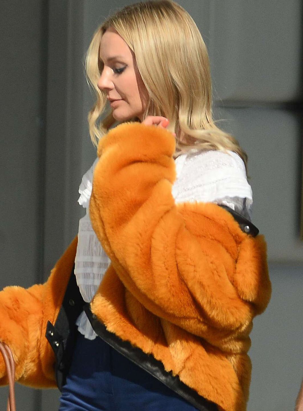 Agnieszka Woźniak-Starak w pomarańczowym futrze na spacerze z psami