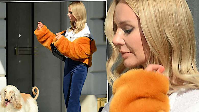 Agnieszka Woźniak-Starak w pomarańczowym futrze na spacerze z psami