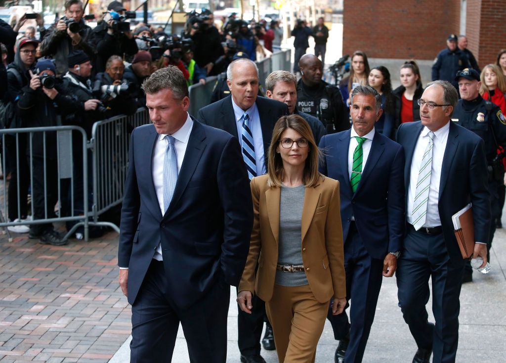 BOSTON, MA - APRIL 3: Actress Lori Loughlin, center in tan, and her husband Mossimo Giannulli, in green tie behind her, leave the John Joseph Moakley United States Courthouse in Boston on April 3, 2019. Hollywood stars Felicity Huffman and Lori Loughlin were among 13 parents scheduled to appear in federal court in Boston Wednesday for the first time since they were charged last month in a massive college admissions cheating scandal. They were among 50 people - including coaches, powerful financiers, and entrepreneurs - charged in a brazen plot in which wealthy parents allegedly schemed to bribe sports coaches at top colleges to admit their children. Many of the parents allegedly paid to have someone else take the SAT or ACT exams for their children or correct their answers, guaranteeing them high scores. (Photo by Jessica Rinaldi/The Boston Globe via Getty Images) 