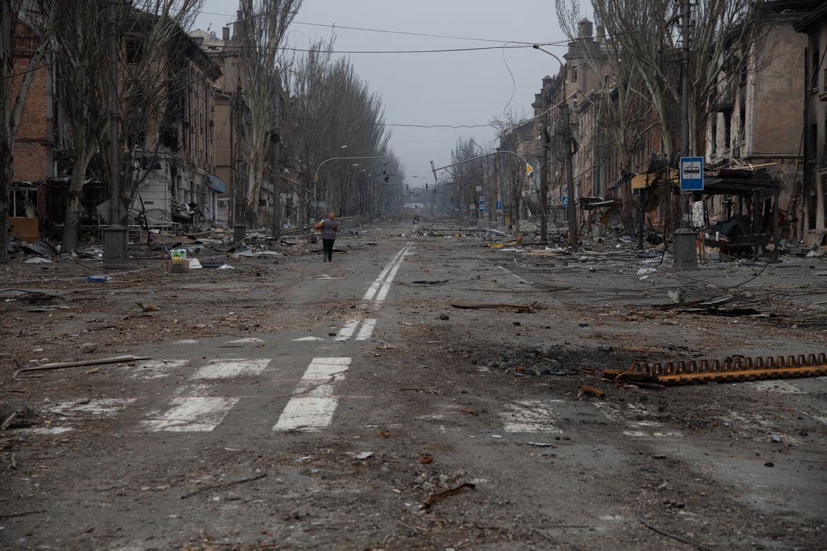 MARIUPOL, UKRAINE - 2022/04/09: A woman walks along in a destroyed Mariupol street. The battle between Russian / Pro Russian forces and the defending Ukrainian forces led by the Azov battalion continues in the port city of Mariupol. (Photo by Maximilian Clarke/SOPA Images/LightRocket via Getty Images)