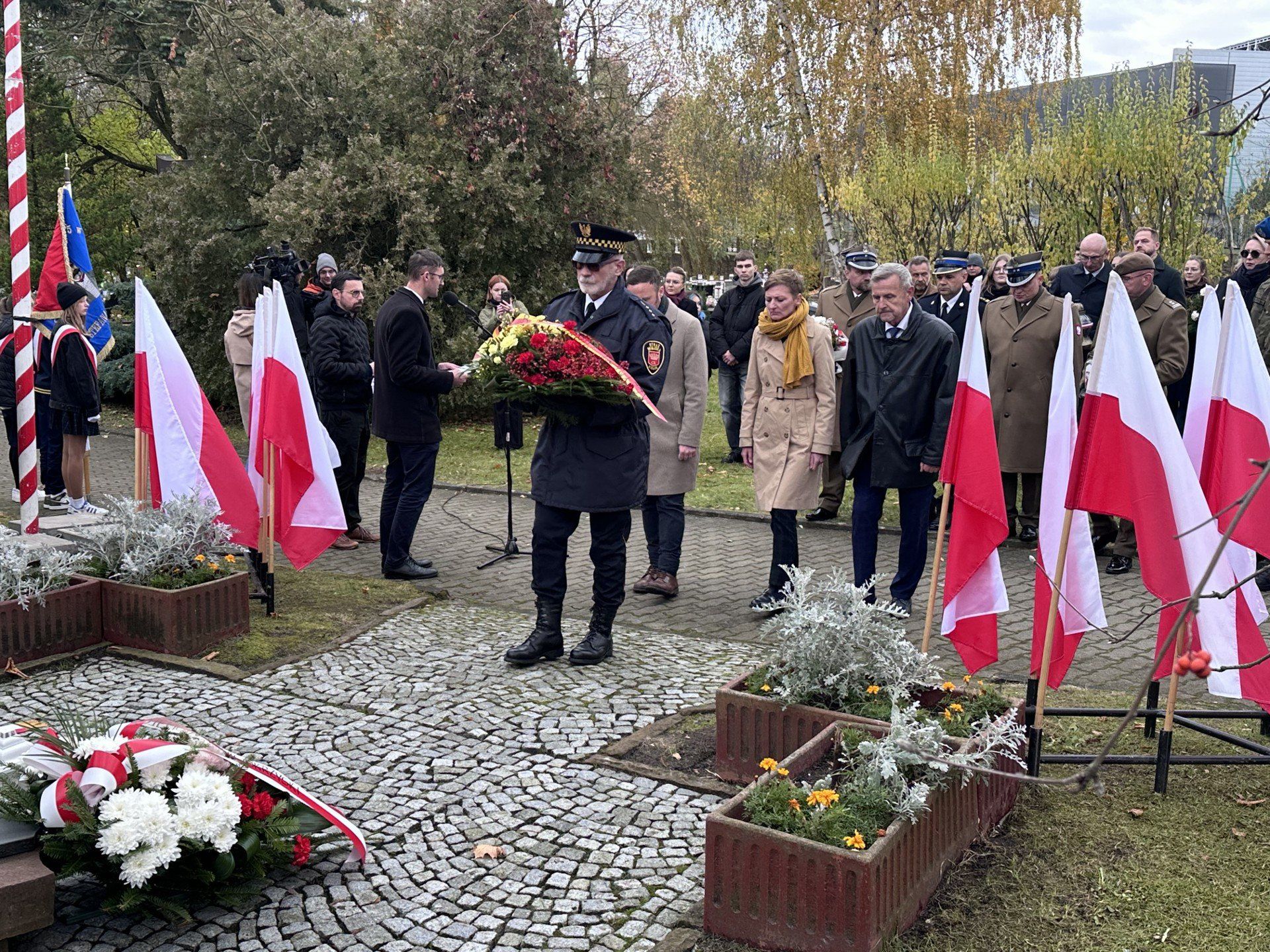 Z kwiatami - Bogusław Kmieć ze Straży Miejskiej w Kielcach, za nim od lewej: radny Michał Piasecki, prezydentka Agata Wojda i wiceprzewodniczący Rady Miasta Kielce Jarosław Machnicki.