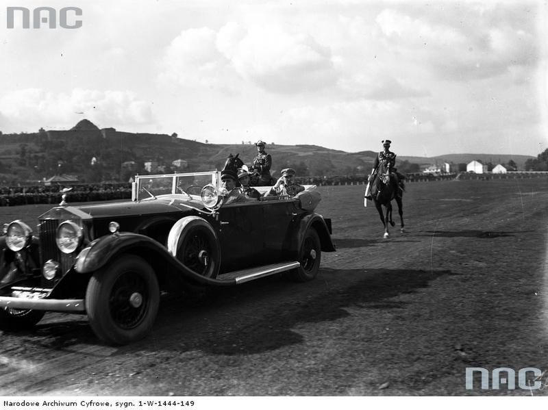 Marszałek Józef Piłsudski w samochodzie Rolls-Royce w towarzystwie płk. Witolda Warthy przejeżdża przez Błonia. Z lewej na koniu gen. Gustaw Orlicz-Dreszer.