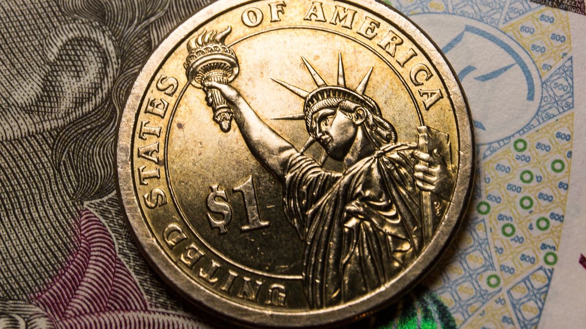 POLAND - 2022/03/09: In this photo illustration, a reverse of the United States 1 dollar coin with Statue of Liberty and Polish 500 zloty banknote are seen displayed. (Photo Illustration by Karol Serewis/SOPA Images/LightRocket via Getty Images)