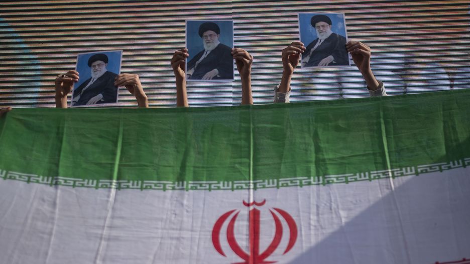 A group of young Iranian schoolboys standing behind an Iran flag hold-up portraits of Iran's Supreme Leader, Ayatollah Ali Khamenei, while performing in an anti-Israel rally protesting the Israeli air strike on Al-Ahli hospital, in northern Tehran, October 20, 2023. Israel's military denied responsibility for the Gaza hospital attack, attributing it to a failed rocket launch by the Palestinian Islamic Jihad group. MORTEZA NIKOUBAZL/NurPhoto (Photo by Morteza Nikoubazl/NurPhoto via Getty Images)