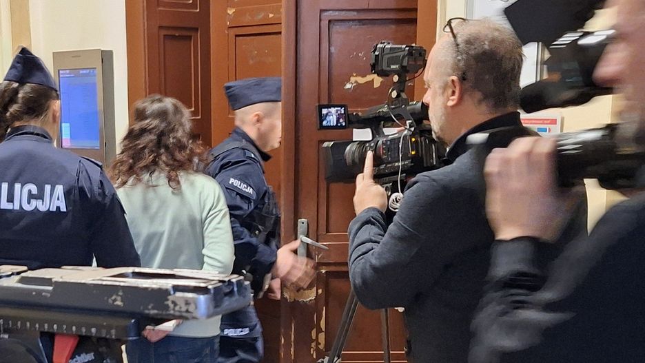 Policjanci prowadzą oskarżoną Ewelinę P. do sali rozpraw