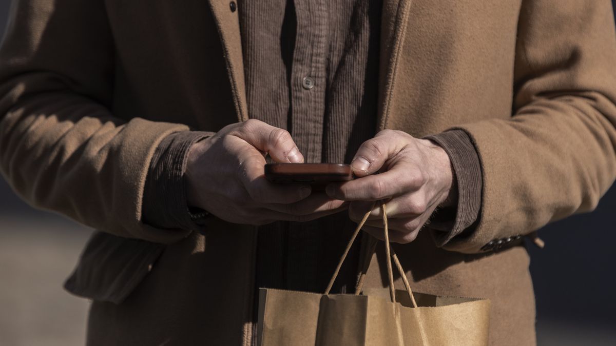 A pedestrian uses a smartphone in New York, US, on Wednesday, March 29, 2023. The worldwide mobile phone market will reach 1,403.0 million units shipped in 2023, down 2.4% from the 1,437.0 million units shipped in 2022, IDC reports. Photographer: Victor J. Blue/Bloomberg via Getty Images