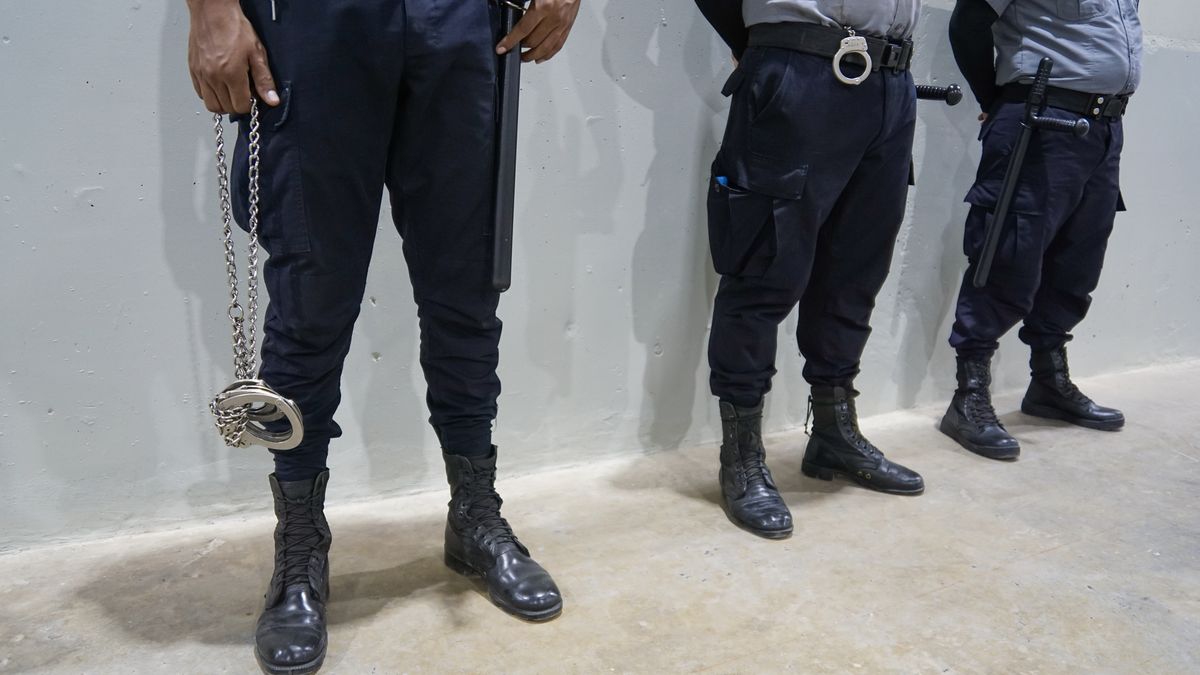 SAN VICENTE, EL SALVADOR - FEBRUARY 02: Corrections officers hold handcuffs during the inauguration of the new maximum security prison for the Confinement of Terrorism (CECOT) in the municipality of Tecoluca, in San Vicente, El Salvador, on February 2, 2023. The authorities of El Salvador opened the Confinement Center against Terrorism (CECOT), a maximum security mega prison created to house up to 40,000 inmates who already saturate the prison system of the Central American country. Since March 2022, when President Nayib Bukele announced the state of emergency, more than 62,000 suspected gang members have been detained. (Photo by Alex Pena/Anadolu Agency via Getty Images)