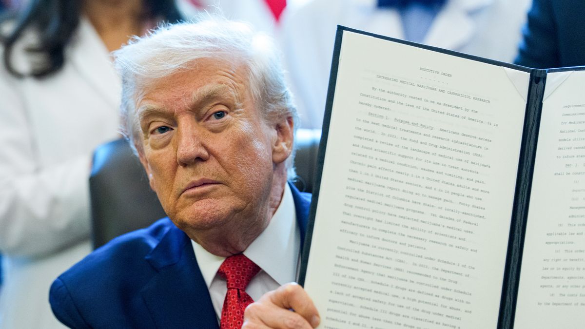 US President Donald Trump displays a signed executive order in the Oval Office of the White House in Washington, DC, US, on Thursday, Dec. 18, 2025. Trump on Thursday signed an executive order directing his administration to move cannabis into a less restrictive federal category, setting in motion a regulatory shift that could alter the legal and commercial landscape for the drug nationwide. Photographer: Aaron Schwartz/CNP/Bloomberg via Getty Images