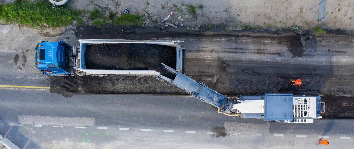 Frezowanie, czyli zrywanie starego asfaltu, który po podgrzaniu w specjalnym recyklerze, nadaje się do ponownego wylania na remontowaną lub budowaną drogę