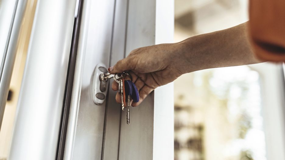 Young woman opening the front door of her apartment building
Woman's hand unlocking the door with a key.
ljubaphoto