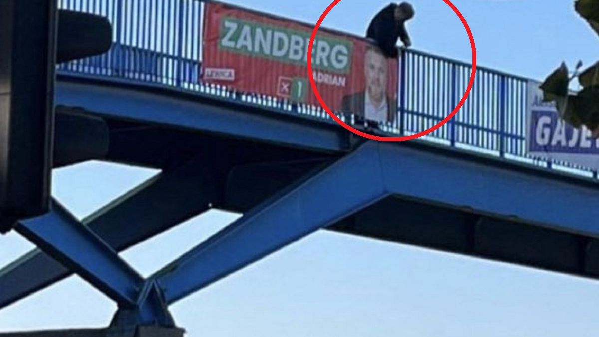 Adrian Zandberg sprzątający plakaty wyborcze.