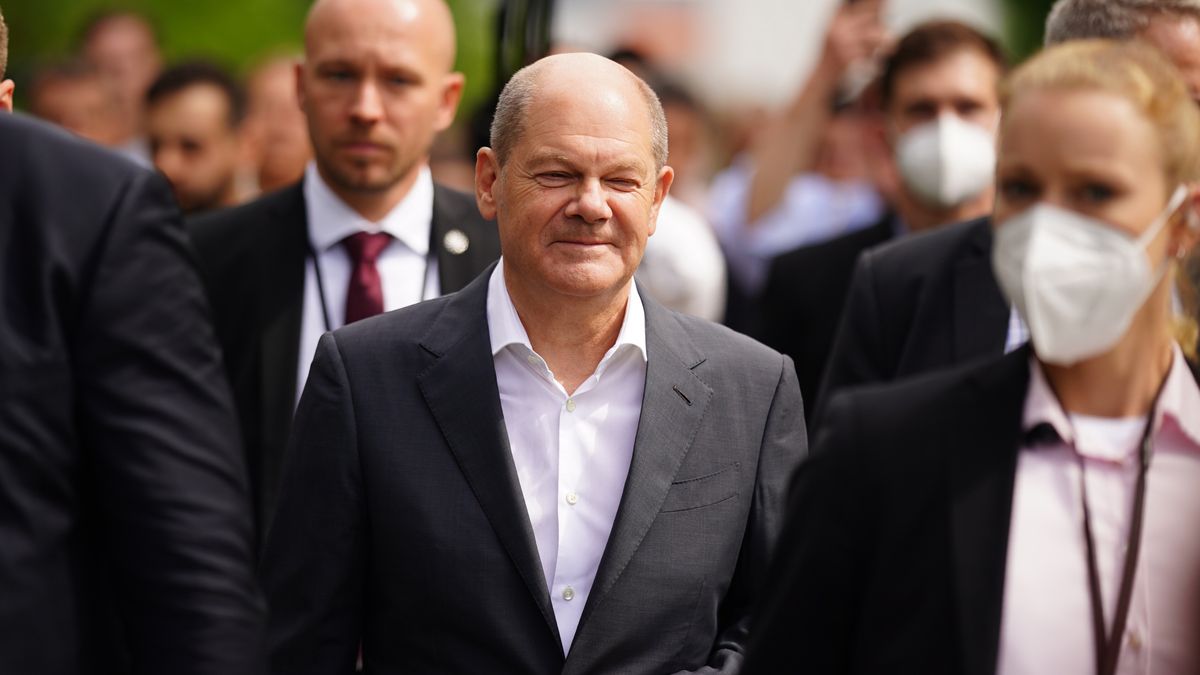 Na zdjęciu w środku kanclerz Niemiec Olaf Scholz idący w tłumie