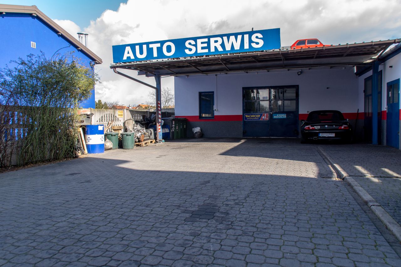 Zazwyczaj na tym placu parkuje sporo aut, które przyjechały do warsztatu na drobne naprawy. Teraz na placu stoją głównie auta rekreacyjne, a większość z nich zaparkowanych jest za mną