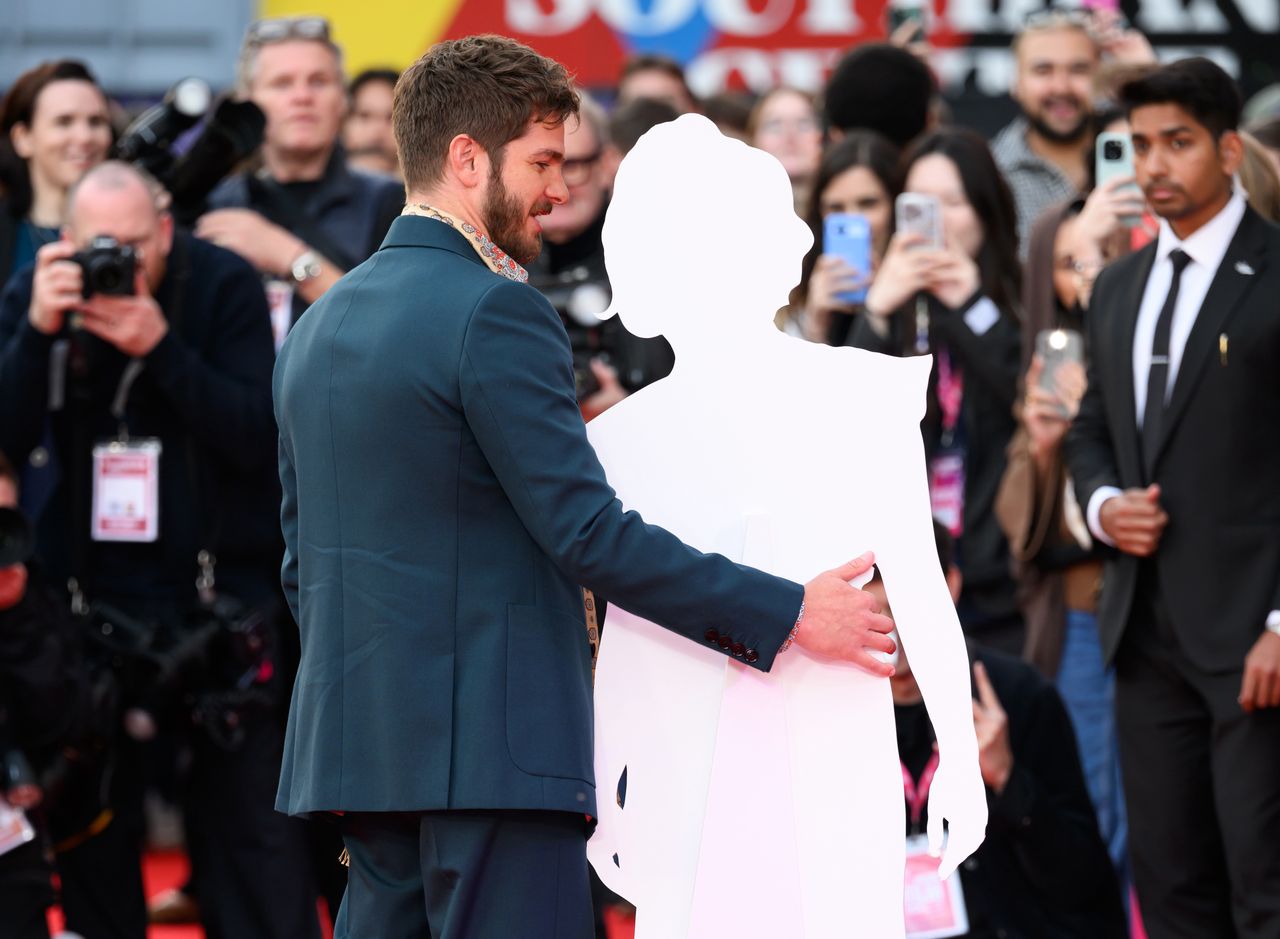 LONDON, ENGLAND - OCTOBER 17: Andrew Garfield poses with a cardboard cutout of Florence Pugh during the "We Live In Time" Headline Gala during the 68th BFI London Film Festival at The Royal Festival Hall on October 17, 2024 in London, England. (Photo by Karwai Tang/WireImage)