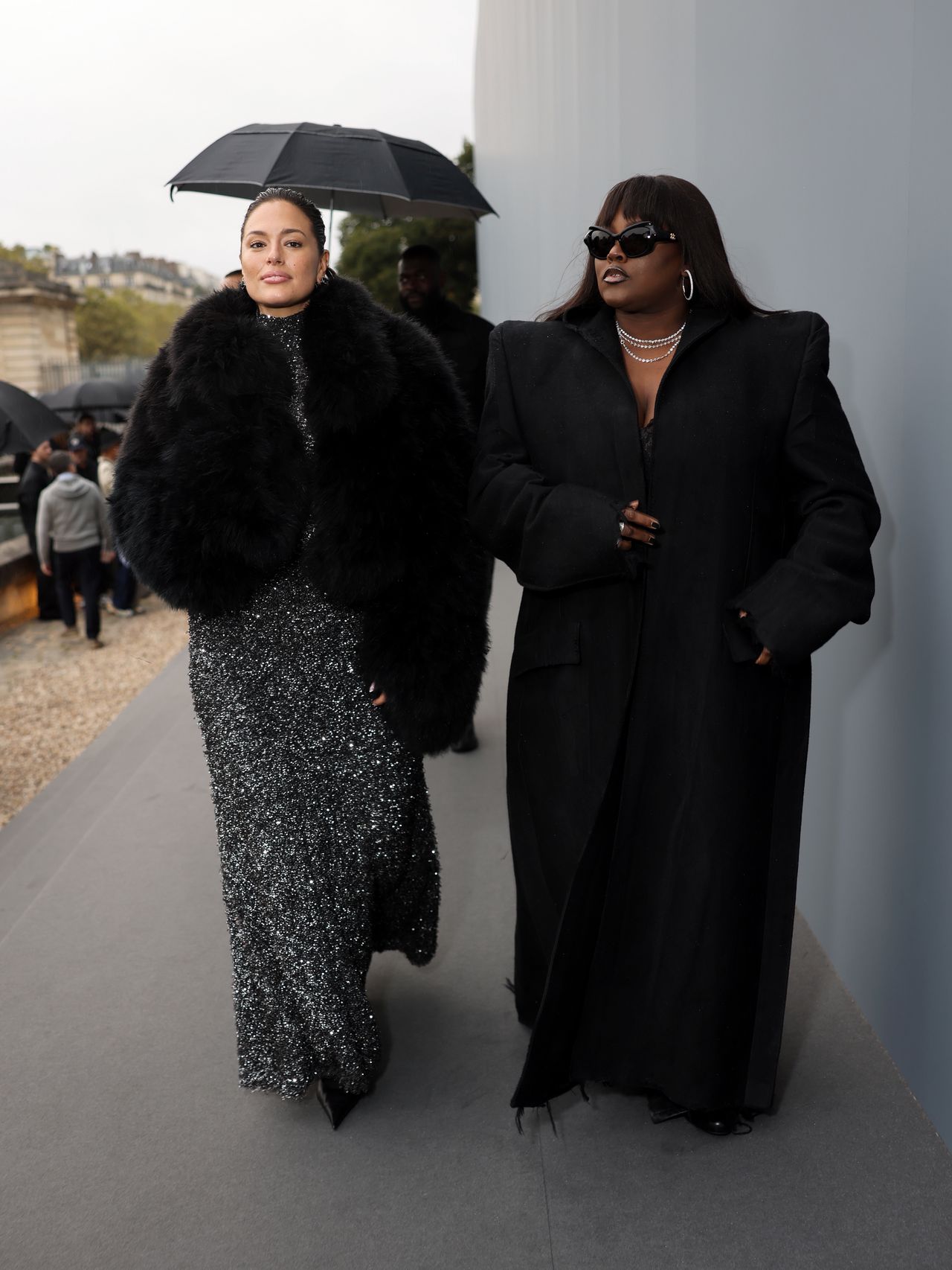 Ashley Graham at Fashion Week in a maxi dress and a fur coat