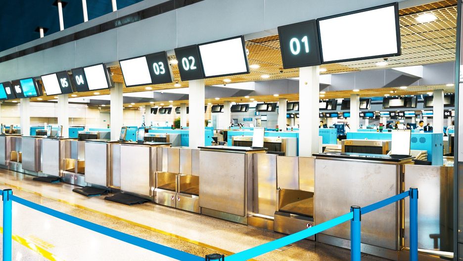 The public check-in area with crowd control barriers of the city airport at early morning time.