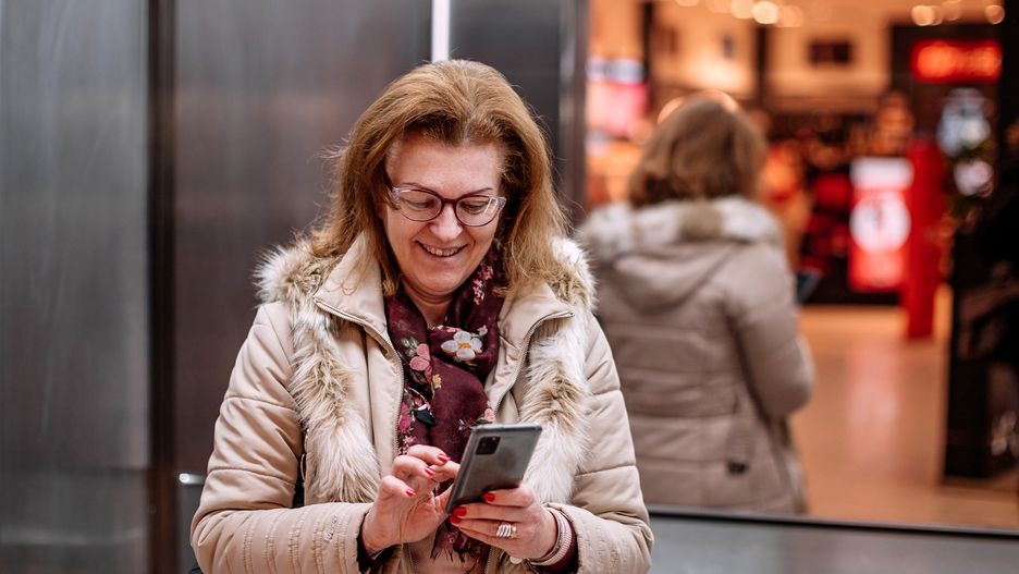 Connecting to bank accountWoman using mobile phone while riding in elevatorDejan Marjanovic