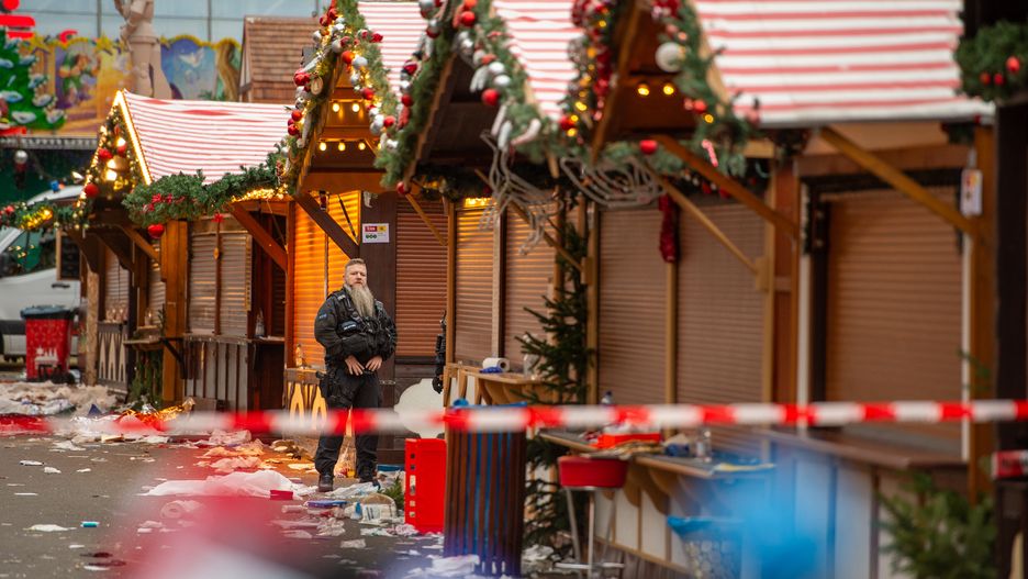 MAGDEBURG, GERMANY - DECEMBER 21: A policeman stands protecting the crime scene of the shuttered Christmas market the day after a terror attack that has left five people dead, including a small child, and over 200 injured on December 21, 2024 in Magdeburg, Germany. Police arrested a man after he drove a black BMW past security obstacles and into the busy Christmas market in the early evening yesterday. The attacker is reportedly a Saudi national who has been living in Germany since 2006 and worked as a psychotherapist. In social media posts he was critical of Germany but also of Islam and the "Islamization" of Germany. He expressed support for policies of the far-right Alternative for Germany (AfD). (Photo by Craig Stennett/Getty Images)