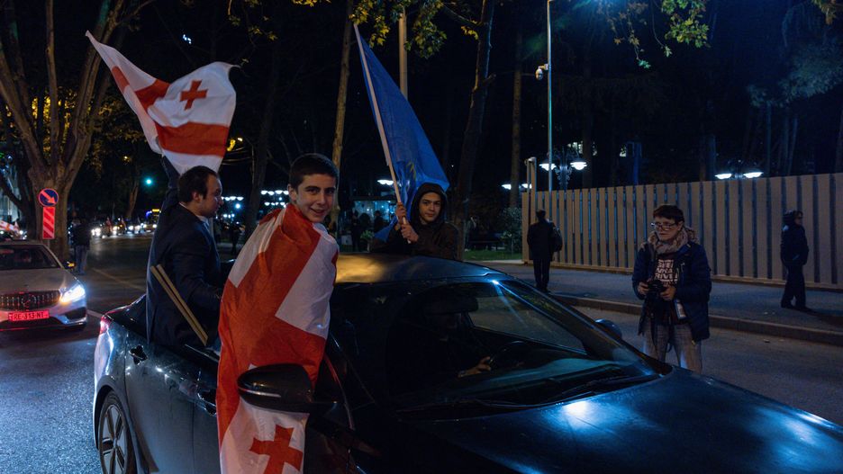 TBILISI, GEORGIA - OCTOBER 26: Georgian Dream Party supporters celebrate the exit poll results outside the new Georgian Dream headquarters during Georgian Elections Day on October 26, 2024 in Tbilisi, Georgia. Georgians are voting on October 26, in a close parliamentary election that analysts say will likely determine whether or not the post-Soviet nation will take a step closer to membership in the European Union (EU). An opposition coalition is challenging the Georgian Dream ruling party, which has been in power since 2012 under the leadership of Bidzina Ivanishvili. The vast majority of Georgians are in favor of joining the EU, however the country's bid to become a member of the bloc was frozen earlier this year, following concerns over the "foreign agents" bill passed in May, which critics say represents a backslide for democracy. (Photo by Diego Fedele/Getty Images)