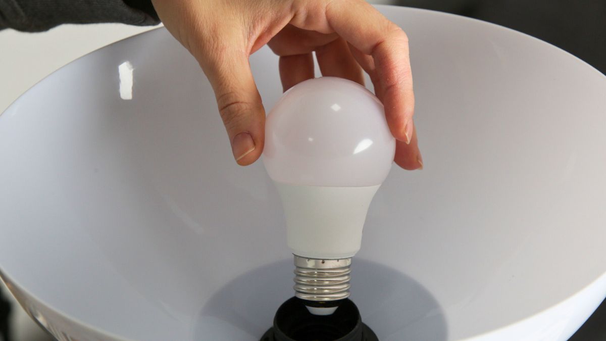 Mężczyzna zmienia żarówkę