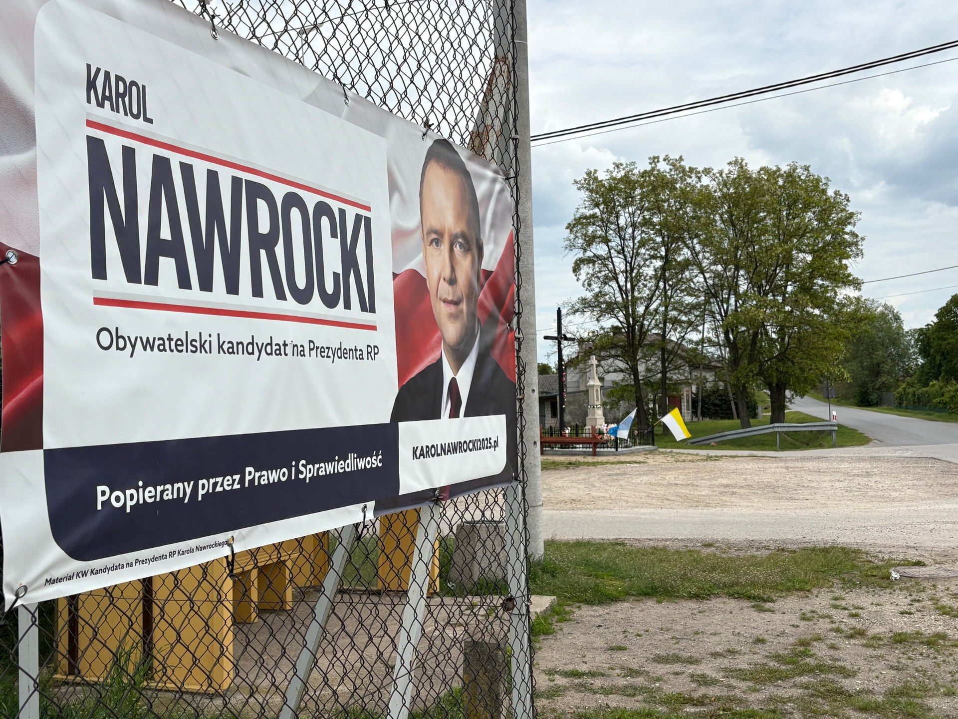 Skrzyżowanie dróg  w gminie Rusinów i plakat wyborczy