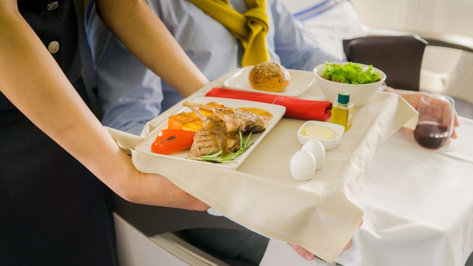 flight attendant serving meal in an airplane
cabin crew serving meal in an airplane
Aureliy