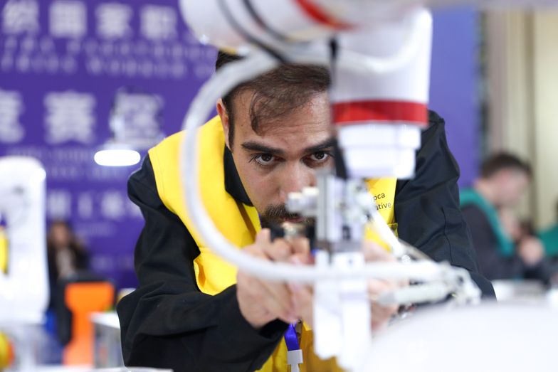 QINGDAO, CHINA - DECEMBER 18: A participant competes in intelligent manufacture and measuring system contest during the third SCO Countries Worker Skills Contest on December 18, 2024 in Qingdao, Shandong Province of China. (Photo by Zhang Xiangyi/China News Service/VCG via Getty Images)