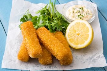 Na obiad przygotowuje pyszne paluszki. Dzieci ustawiają się w kolejce