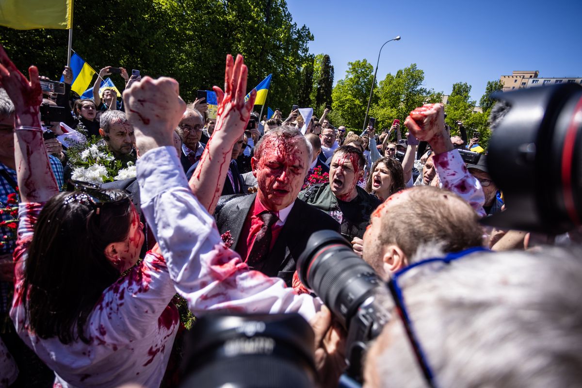 Russian Ambassador Sergey Andreev stands between Pro-Ukrainian demonstrators after he was covered with red substance when he was trying to lay a wreath on Russian Victory Day in Warsaw, Poland on May 9, 2022. (Photo by Stringer/Anadolu Agency via Getty Images)