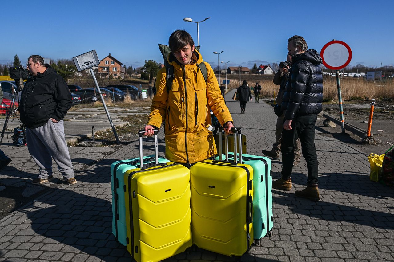 Dmitro ciągnie ze sobą walizki na granicy polsko-ukraińskiej.