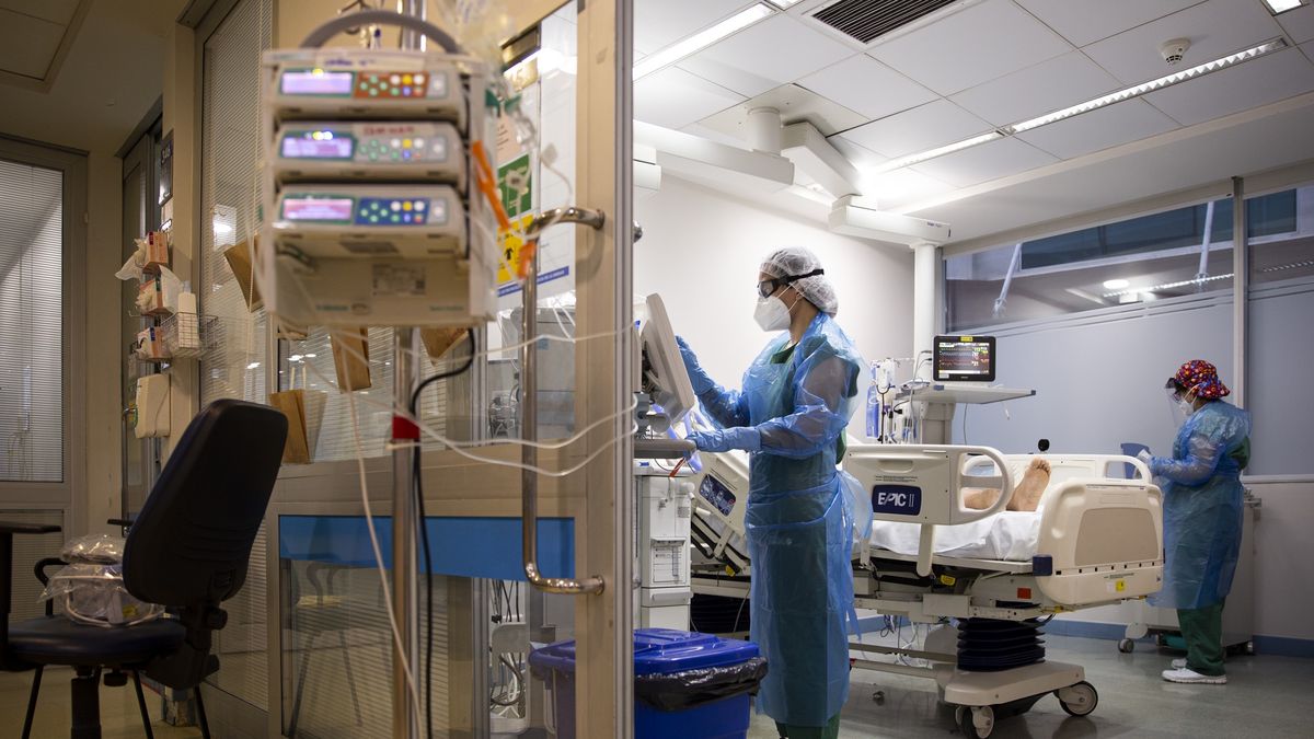 Na zdjęciu szpital. Widok na salę, dwóch lekarzy i pacjenta na łóżku