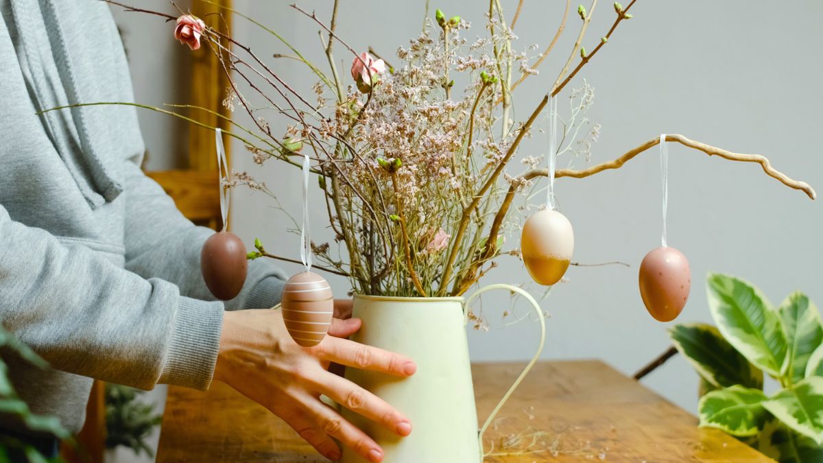 Kobieta stawia dekorację wielkanocną na stole
