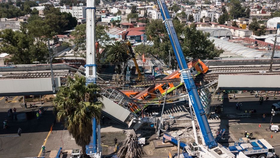 MEXICO CITY, MEXICO - MAY 04: Workers remove the wreckage of a train from the site of an accident after a metro overpass collapsed as a train was traveling over it in Mexico City, Mexico on May 04, 2021. At least 23 people have been killed and 70 injured after a metro overpass and train crashed down onto a busy road in Mexico City late on Monday. (Photo by Manuel Velasquez/Anadolu Agency via Getty Images)