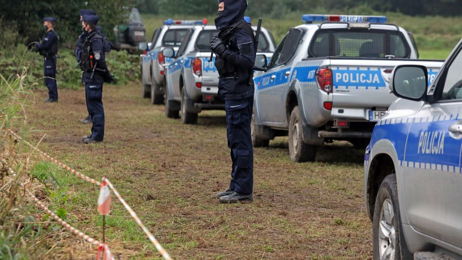 Usnarz Górny (pow. sokólski), 30.08.2021. Policja na polsko-białoruskiej granicy w pobliżu miejscowości Usnarz Górny, 30 bm. Mija kolejny dzień, w którym grupa cudzoziemców koczuje na granicy polsko-białoruskiej. Przejścia na polską stronę pilnują żołnierze i funkcjonariusze SG. Natomiast z białoruskiej strony przed ewentualnym odwrotem zagradzają im drogę tamtejsze służby. (ar/amb) PAP/Artur Reszko