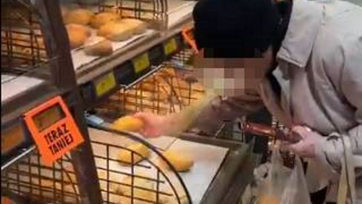 Starsza pani wybiera bułki w Biedronce. 