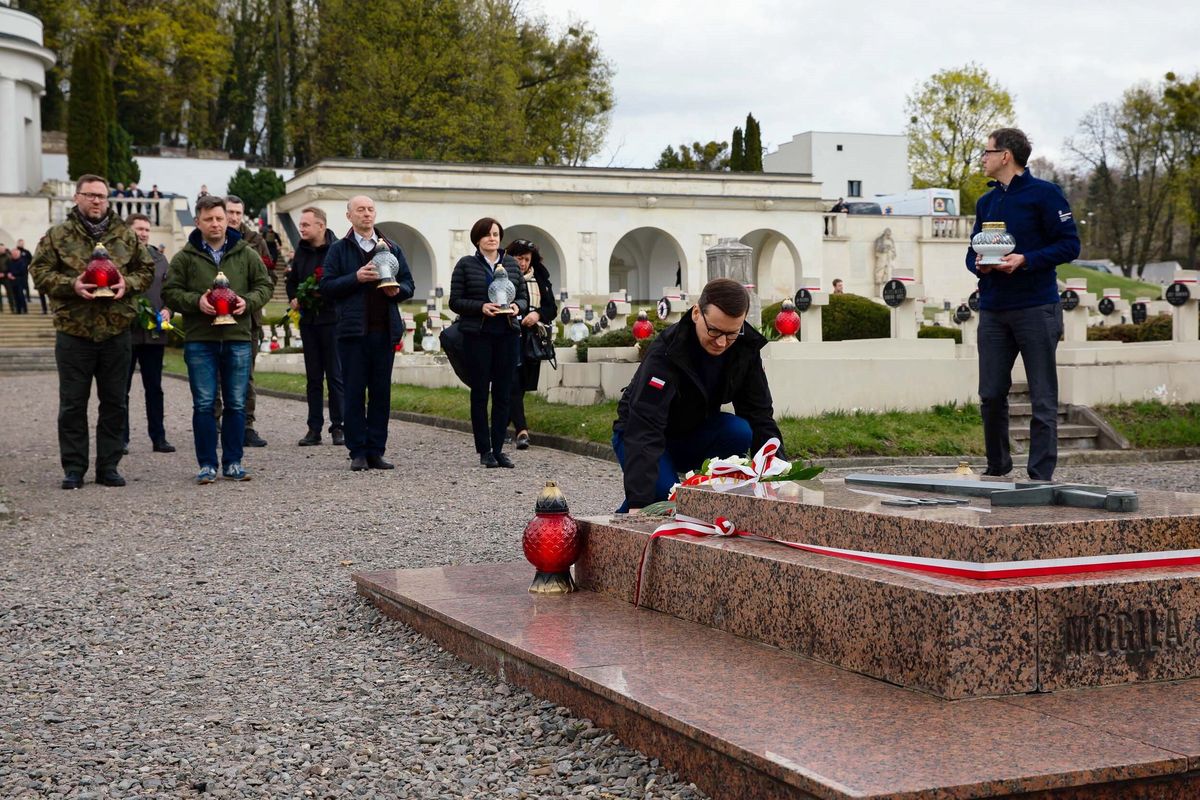 Lwów, Ukraina, 19.04.2022. Premier Mateusz Morawiecki (2P) oraz minister-członek Rady Ministrów, szef KPRM Michał Dworczyk (2L) na Cmentarzu Orląt Lwowskich, 19 bm. we Lwowie. Szef polskiego rządu złożył kwiaty i zapalił znicze m.in. przy Mogile Nieznanego Żołnierza oraz pod mogiłą żołnierzy poległych w obecnej wojnie rosyjsko-ukraińskiej. (kf) PAP/Krystian Maj/KPRM HANDOUT EDITORIAL USE ONLY NO SALES