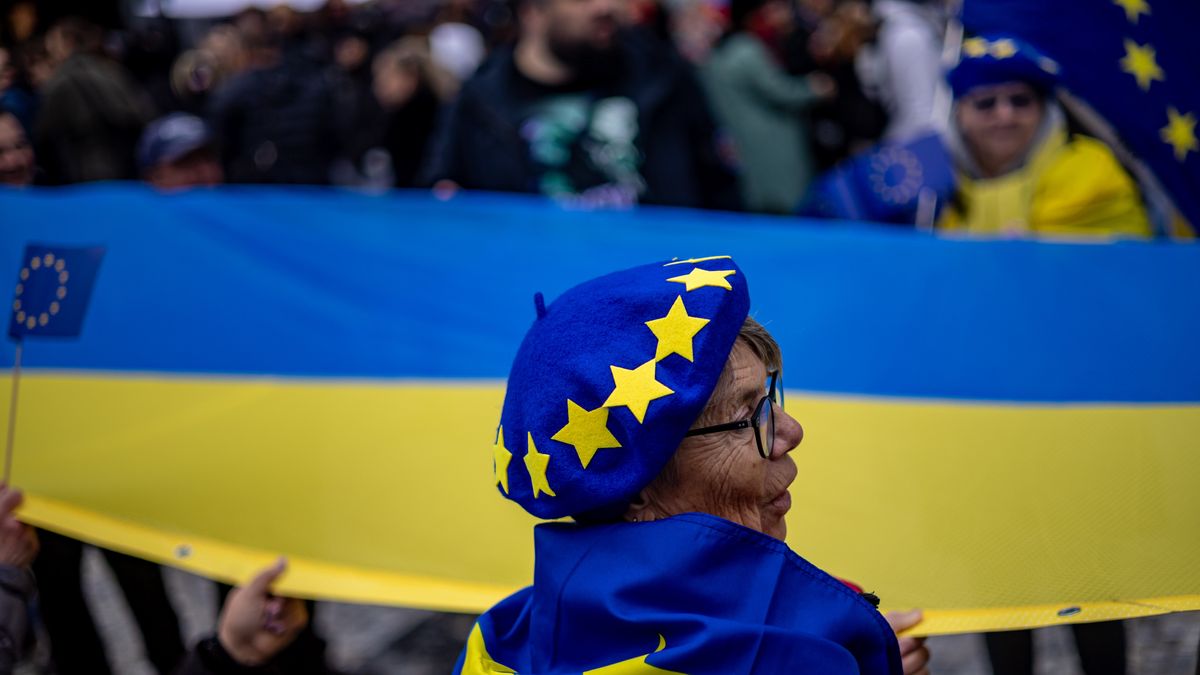 A woman a hat and flag with the EU symbols stands in front of large Ukrainian flag with people participating in a supporting gathering, marking the 36th anniversary of the Velvet Revolution in Prague, Czech Republic, 17 November 2025. The Czech Republic marks the 36th anniversary of the Velvet Revolution, commemorating the events of 17 November 1989, when, after the suppression of a student demonstration at Narodni Street, the Communist leadership soon crumbled, and the presidency was taken over by the playwright and human rights activist Vaclav Havel. EPA/MARTIN DIVISEK Dostawca: PAP/EPA.