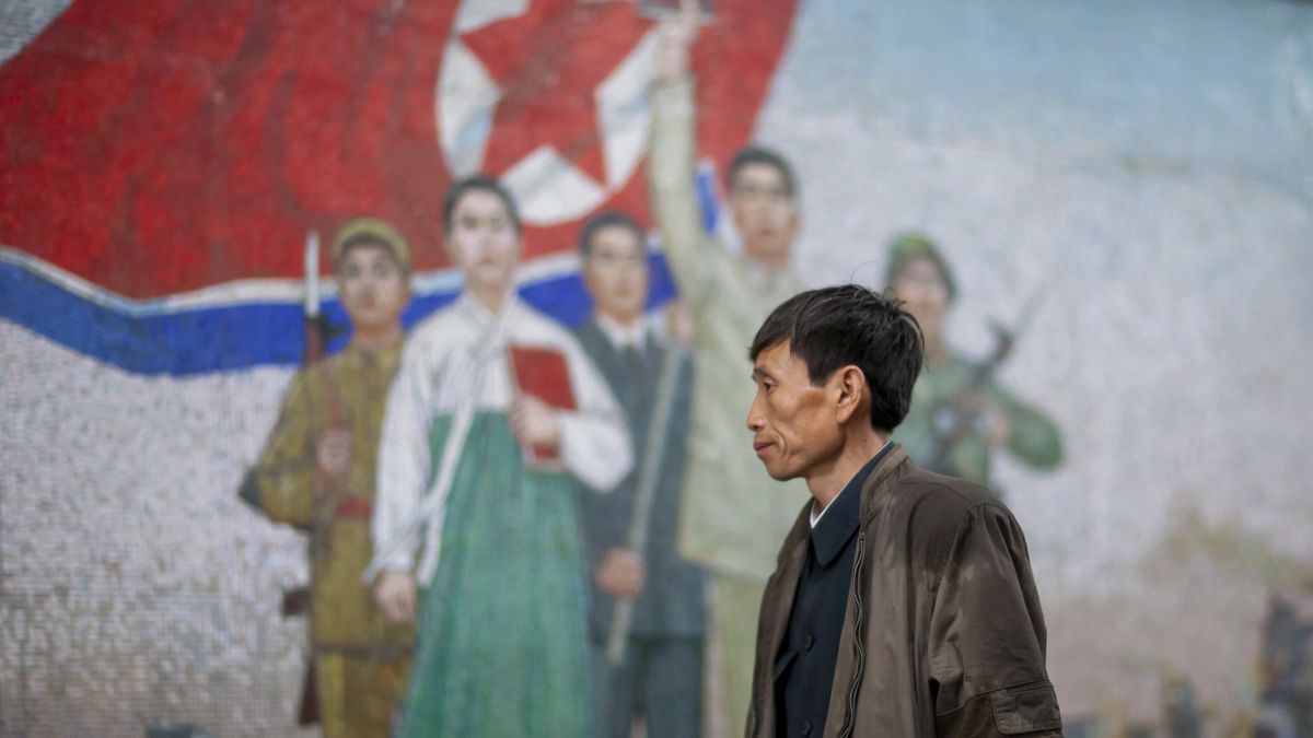 PYONGYANG, NORTH KOREA - APRIL 26: North Korean man in front of a fresco in Puhung metro station, DGC, Pyongyang, North Korea on April 26, 2010 in Pyongyang, North Korea.