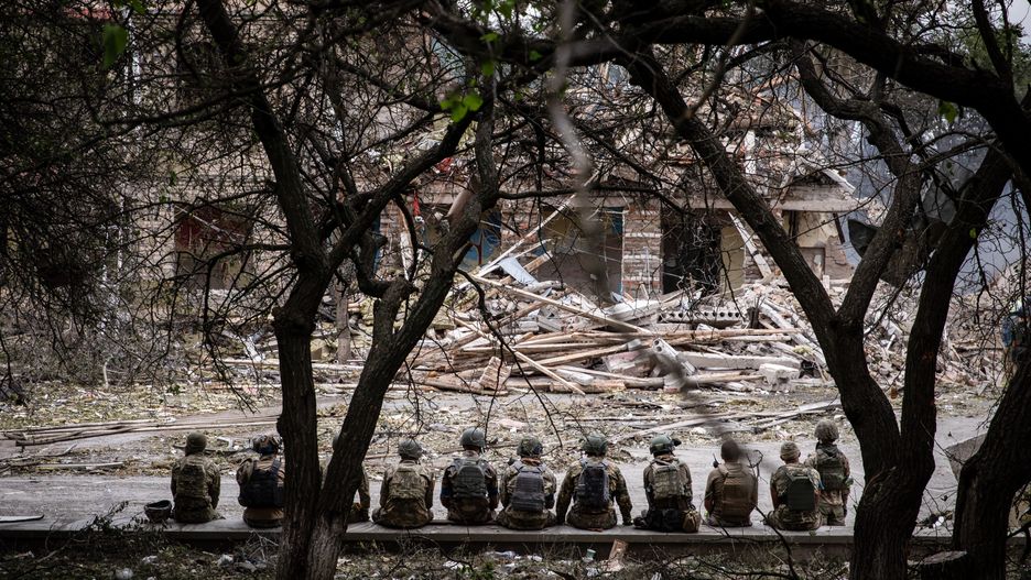 KRAMATORSK, DONETSK, UKRAINE - 2022/07/21: Ukrainian soldiers are sitting at the shelling scene of a destroyed school in Kramatorsk. As Russia stepped up its "military operation" in Ukraine, a school in Kramatorsk was hit and destroyed by Russian rockets on July 21. Ukrainian officials claimed they had discovered at least three bodies. Kramatorsk, a strategic railway hub city of more than 150,000 people before the Russian invasion, will more likely become the main focus of the Russian forces in the east. (Photo by Alex Chan Tsz Yuk/SOPA Images/LightRocket via Getty Images)